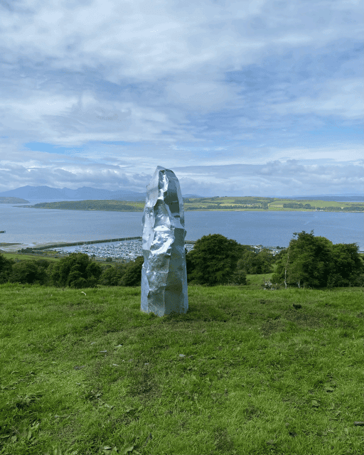 standing stone model on hilltop with sea in background, by artist ruby loveday