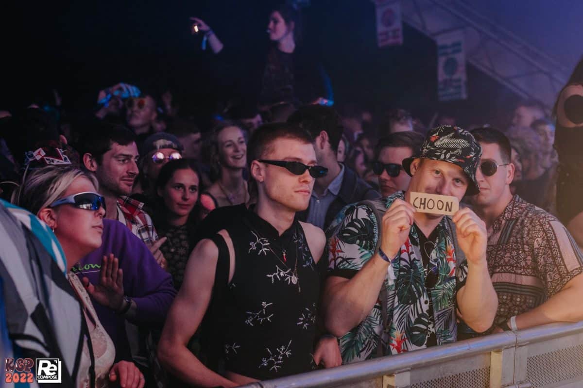 audience dancing at landing stage at kelburn garden party, one audience member holds up sign saying "choon"