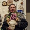 artist duncan robertson holding sculpted head and flowers