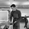 black and white photo of artist tom matthews screen printing